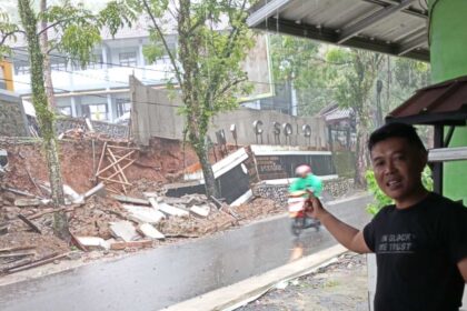 P2BK Cisolok Andri Firmansah saat menunjukkan kondisi talud SMAN 1 Cisolok Sukabumi yang ambruk. | Foto: Muri